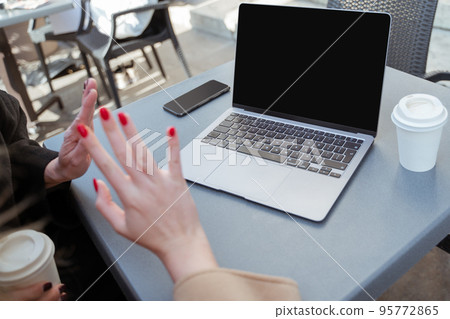 Picture of laptop on the table and female hands with red nails Picture of laptop on the table and female hands with red nails 95772865