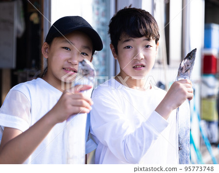 A child with a caught swordfish 95773748