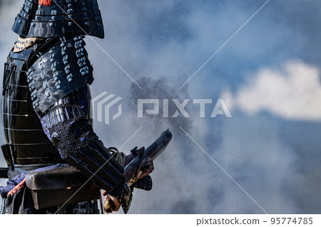 Armored warrior shooting a matchlock gun 95774785