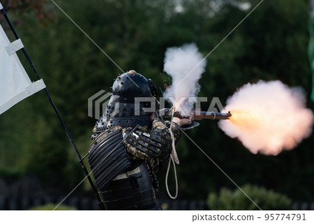 Armored warrior shooting a matchlock gun 95774791