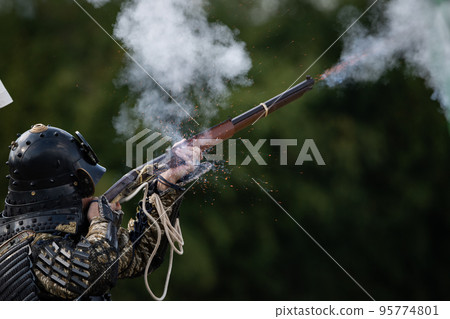 Armored warrior shooting a matchlock gun 95774801