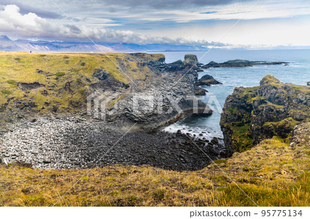Coastline cliffs with basalt columns at Arnarstapi, scenic and thriving tourism destination in Iceland. 95775134