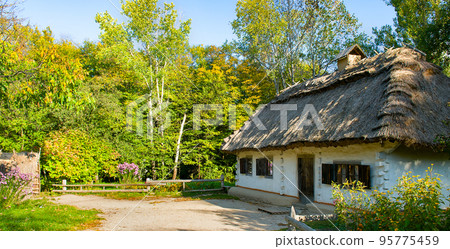 Wooden houses in colored trees taken in park in Pirogovo museum, Kiev, Ukraine. Wide photo. Wooden houses in colored trees taken in park in Pirogovo museum, Kiev, Ukraine. Wide photo. 95775459