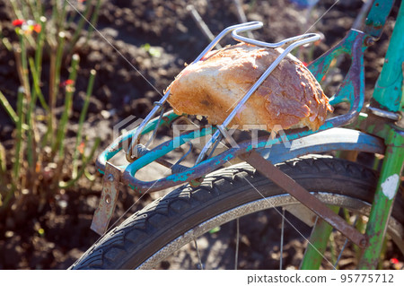 piece of bread on the trunk of an old bicycle