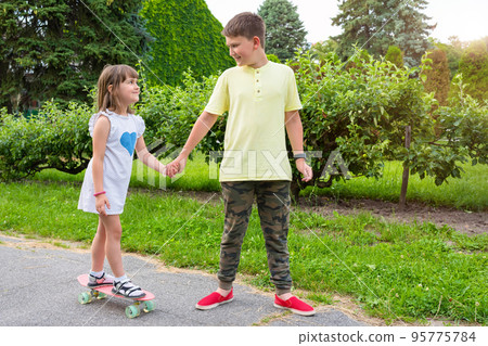 Children play in the park outdoors on a sunny summer day Children play in the park outdoors on a sunny summer day 95775784