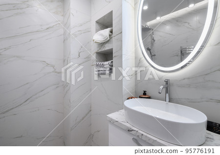 White bathroom interior with marble tiles on the walls White bathroom interior with marble tiles on the walls 95776191