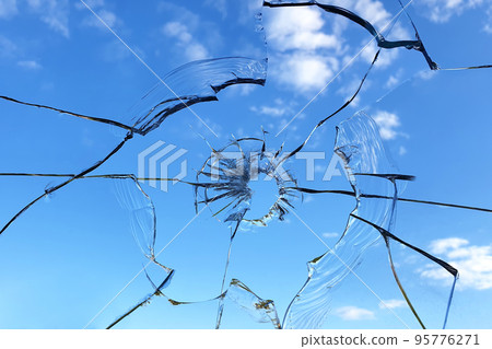 Broken glass window on blue sky background Broken glass window on blue sky background 95776271