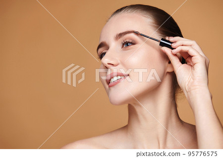 woman with perfect shape eyebrows on beige background. 95776575