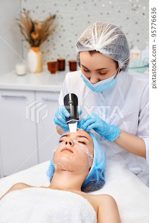 face of woman while procedure ultrasonic cleansing face of woman while procedure ultrasonic cleansing 95776636