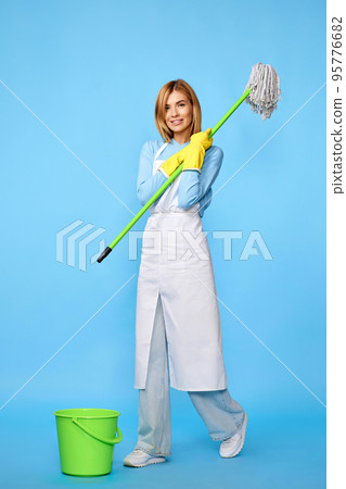 woman in rubber gloves and cleaner apron washing floor with mop woman in rubber gloves and cleaner apron washing floor with mop 95776682