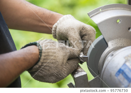 The worker regrinding the lathe tool with dressing wheel. 95776730