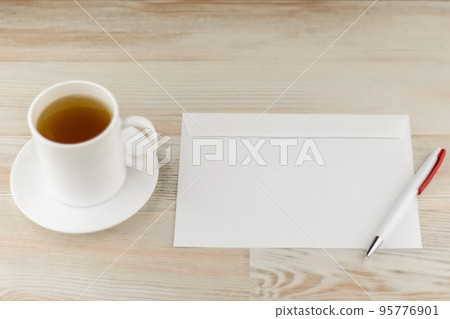 leisurely work in the office - an envelope prepared for writing and sending letters and white Cup with a refreshing green tea are also close by 95776901