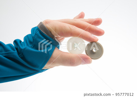 white plastic gears in hand. machine motion transmission mechanism 95777012