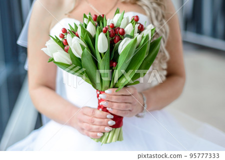 White wedding bouquet of tulips in the hands of the bride blonde 95777333