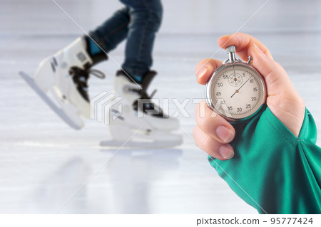 measuring speed on skates with a stopwatch. hand with a stopwatch measuring speed on skates with a stopwatch. hand with a stopwatch 95777424