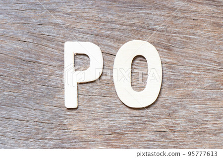 Alphabet letter in word PO (Abbreviation of purchase order) on wood background 95777613