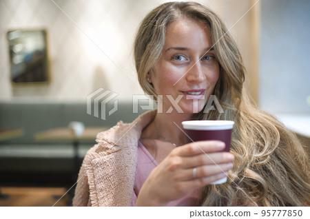 Happy woman drinking coffee in a restaurant Happy woman drinking coffee in a restaurant 95777850