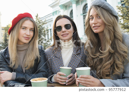 Happy girls at a terrace drinking coffee Happy girls at a terrace drinking coffee 95777912