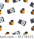 Photographic film in a reel and a camera on a white background. 95778155