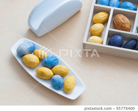 dish with nuts next to the box full of nuts 95778400