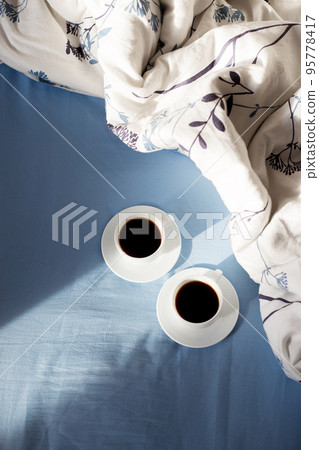 two cups of coffee in bed, sunlight 95778417
