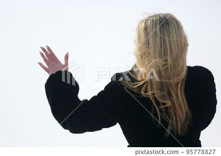 the girl with long hair from behind with his hand raised. the girl with long hair from behind with his hand raised. 95778827