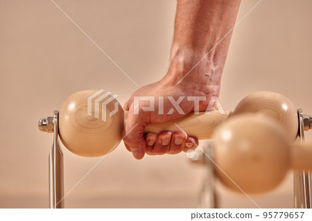 Fit man doing a lunge stretch yoga pilates exercise to strengthen and tone his muscles using a reformer in a gym Fit man doing a lunge stretch yoga pilates exercise to strengthen and tone his muscles using a reformer in a gym 95779657