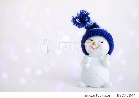 Christmas background. Happy snowman standing in winter christmas landscape with a glass. Merry christmas and happy new year greeting card. Funny snowman in hat. Banner. Copy space 95779844
