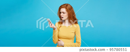 Lifestyle and Technology concept - Portrait of cheerful happy ginger red hair girl with joyful and exciting smiling to camera. Isolated on Blue Pastel Background. Copy space. Lifestyle and Technology concept - Portrait of cheerful happy ginger red hair girl with joyful and exciting smiling to camera. Isolated on Blue Pastel Background. Copy space. 95780551