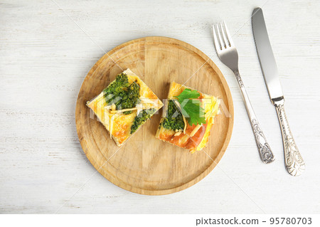 Tasty broccoli casserole served on white wooden table, flat lay Tasty broccoli casserole served on white wooden table, flat lay 95780703