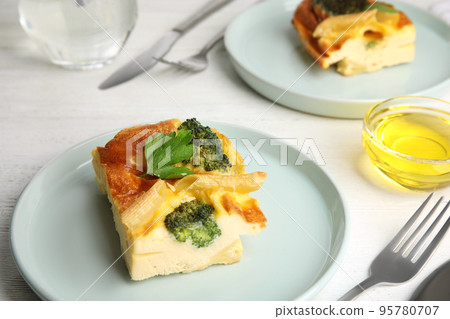 Tasty broccoli casserole served on white wooden table Tasty broccoli casserole served on white wooden table 95780707