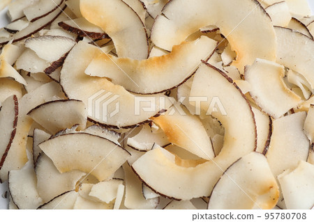 Delicious fresh coconut chips as background, closeup Delicious fresh coconut chips as background, closeup 95780708