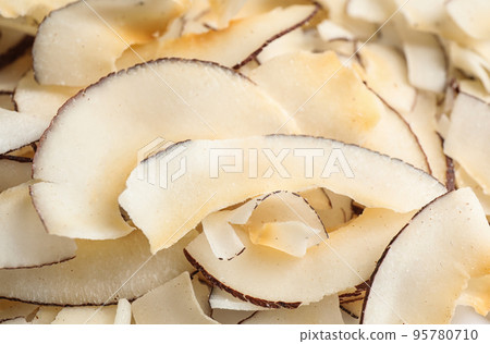 Delicious fresh coconut chips as background, closeup Delicious fresh coconut chips as background, closeup 95780710