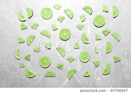 Slices of fresh juicy lime on marble table, flat lay 95780847