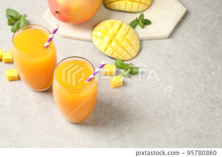 Fresh delicious mango drink on light table. Space for text Fresh delicious mango drink on light table. Space for text 95780860