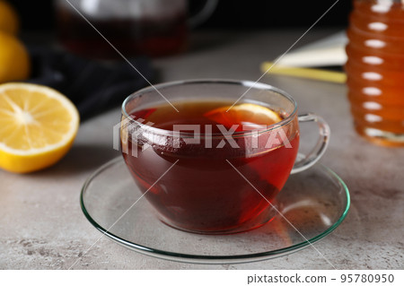 Fresh tea with honey and lemon on light grey table, closeup Fresh tea with honey and lemon on light grey table, closeup 95780950