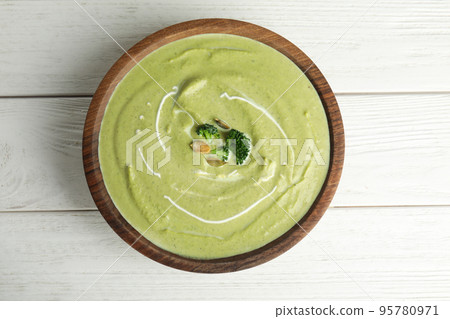 Delicious broccoli cream soup served on white wooden table, top view Delicious broccoli cream soup served on white wooden table, top view 95780971