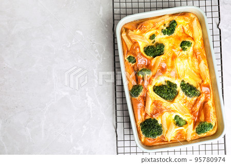 Tasty broccoli casserole in baking dish on cooling rack, top view. Space for text Tasty broccoli casserole in baking dish on cooling rack, top view. Space for text 95780974
