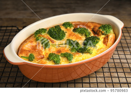 Tasty broccoli casserole in baking dish on cooling rack Tasty broccoli casserole in baking dish on cooling rack 95780983
