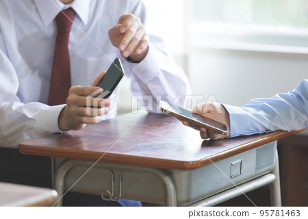 Two students operating smartphones Two students operating smartphones 95781463