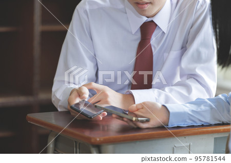 操作智能手機的兩名學生 操作智能手機的兩名學生 95781544