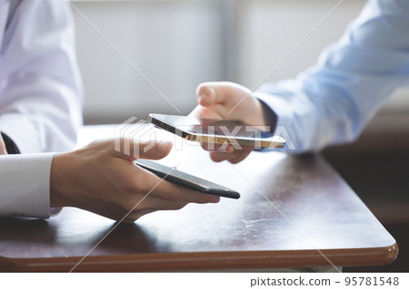 Two students operating smartphones 95781548