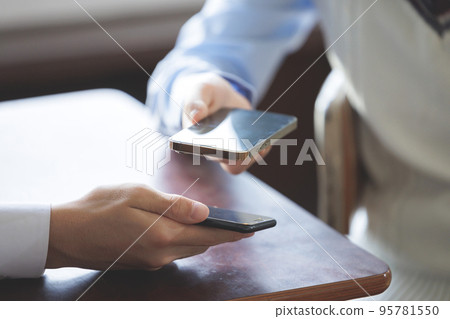 Two students operating smartphones 95781550