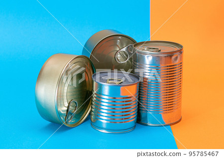 A Group of Stacked Tin Cans with Blank Edges on Split Blue and Orange Background 95785467