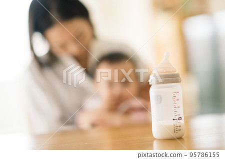 媽媽和寶寶坐在椅子上，帶著奶瓶 95786155