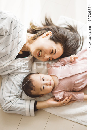 baby and mom lying on towel 95786834