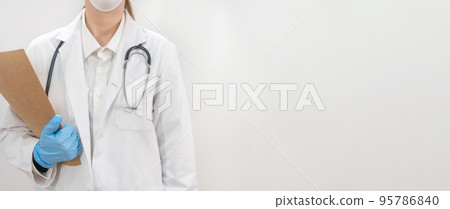 Banner with young attractive female doctor wearing blue gloves and blur hospital in the background. copy space for text. 95786840