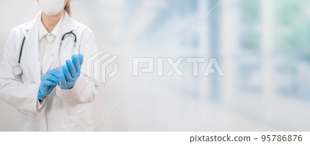 Banner with young attractive female doctor wearing blue gloves and blur hospital in the background. copy space for text. 95786876