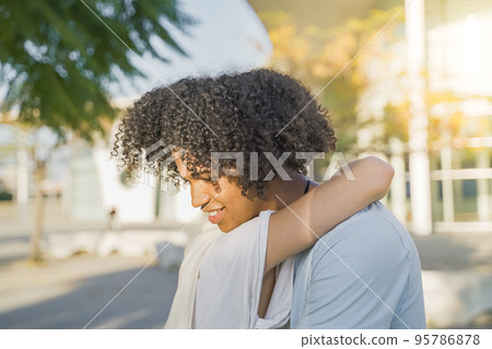 Friendly hug concept, smiling millennial black man and woman cuddling, friendship and good warm relations. 95786878