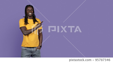 Smiling african american young man pointing at copy space, panorama 95787346